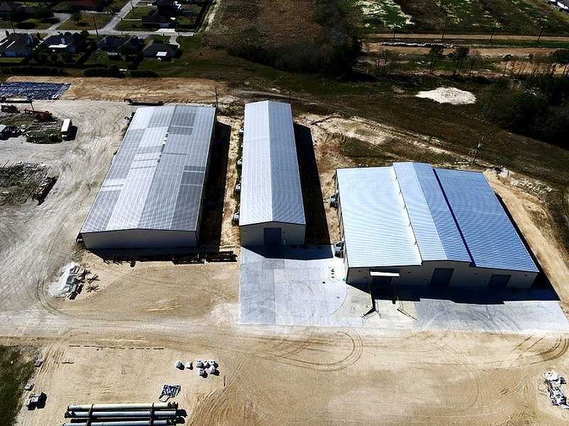 Aerial view of three finished metal buildings and a concrete yard