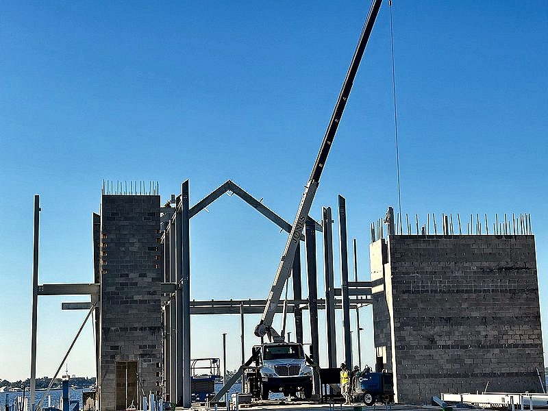 Boom truck setting steel between two masonry towers