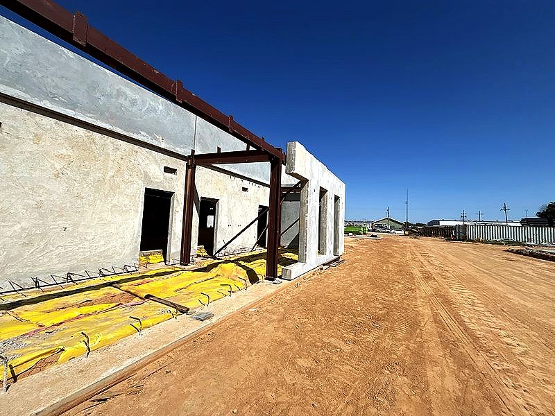 Steel beams tied into concrete wall panels on a job site