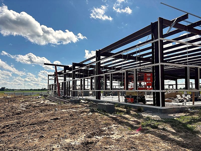 Red-iron structural steel frame going up under a blue sky