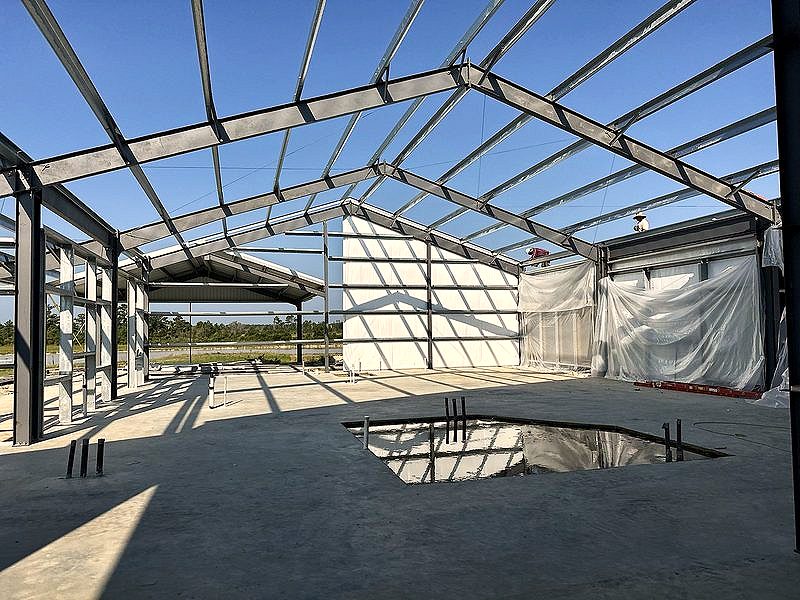 Open steel roof framing against a blue sky