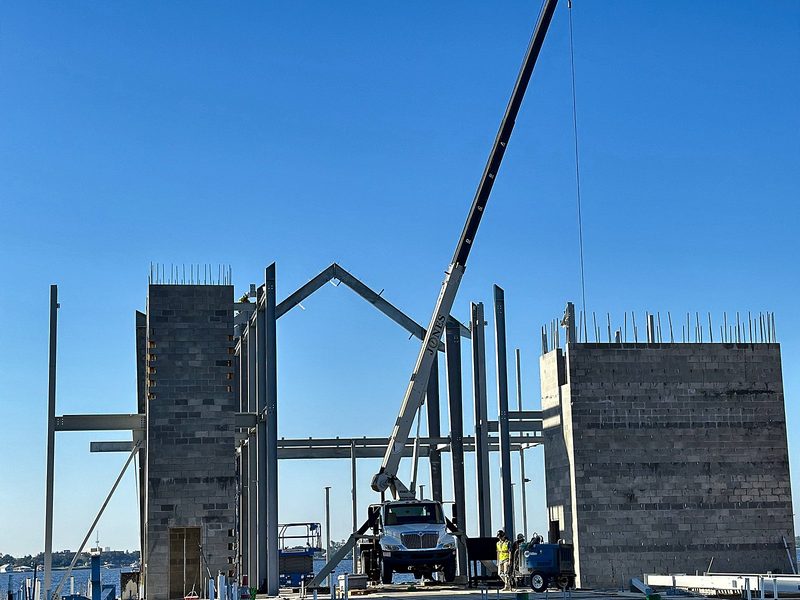Boom truck setting steel between two masonry towers